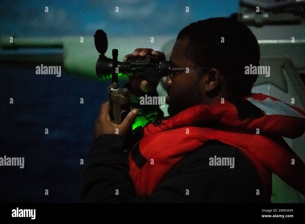 PHILIPPINE SEA (March 17, 2022) Gunner’s Mate 2nd Class Taquan Taylor, from Mobile, Alabama, mans the Mark 38 – 25 mm machine gun aboard the Arleigh Burke-class guided-missile destroyer USS Dewey (DDG 105) while conducting routine operations underway in the U.S. 7th Fleet area of responsibility. Dewey is assigned to Destroyer Squadron (DESRON) 15 and is underway supporting a free and open Indo-Pacific. CTF 71/DESRON 15 is the Navy’s largest forward-deployed DESRON and the U.S. 7th Fleet’s principal surface force. Stock Photo