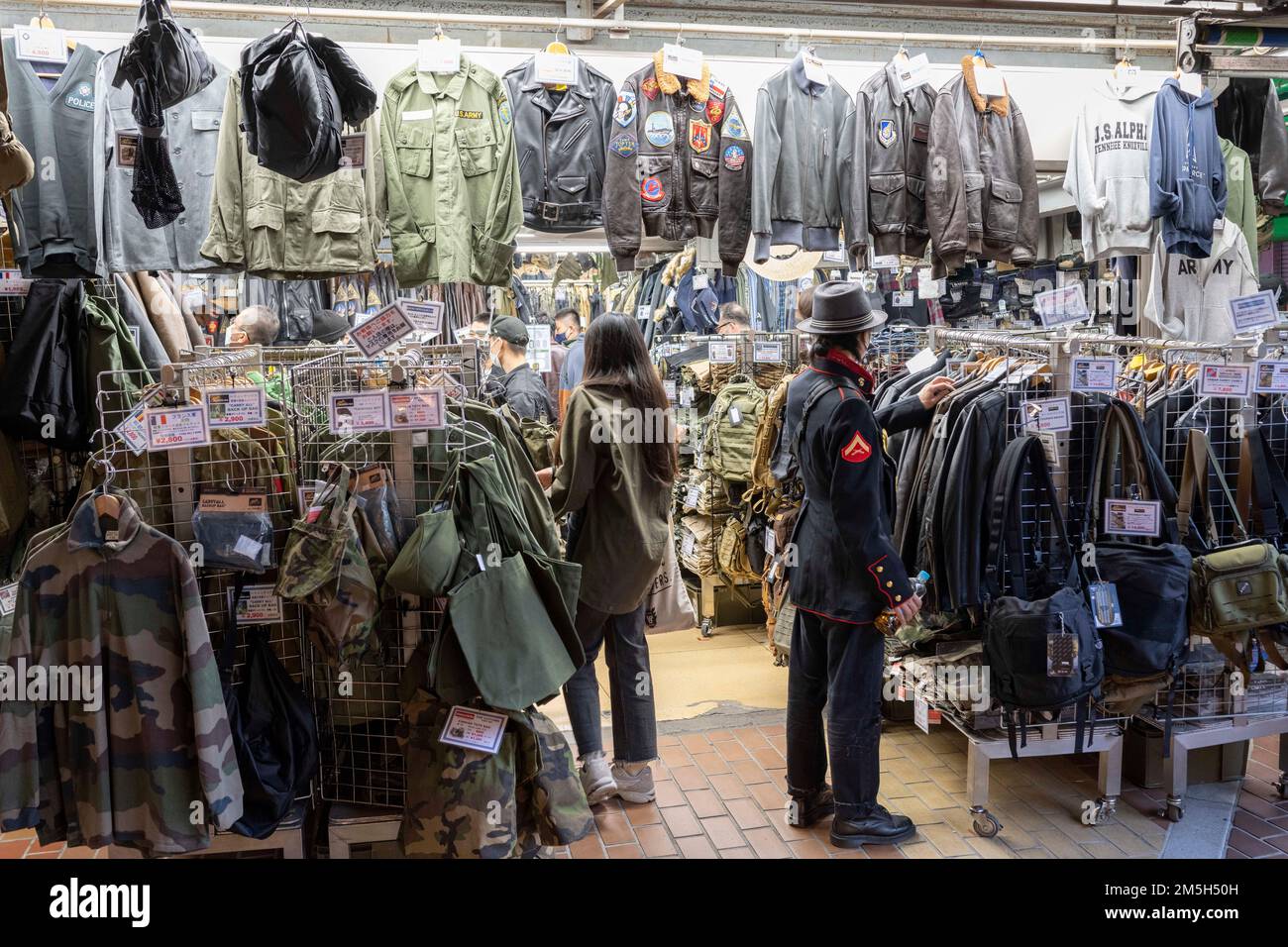 Tokyo, Japan. 4th Nov, 2022. A Tokyoite in U.S. Marine Corps dress blues shopping at a U.S. military uniform-themed Army Navy surplus shop selling camouflaged fatigues and military clothing jackets for fashion in the markets under the JR East lines in Ueno.Japan has recently reopened to tourism after over two years of travel bans due to the COVID-19 pandemic. The Yen has greatly depreciated against the USD US Dollar, creating economic turmoil for international trade and the Japanese economy. Japan also is now experiencing a daily count of over 100,000 new COVID-19 cases a day, with Tokyo Stock Photo