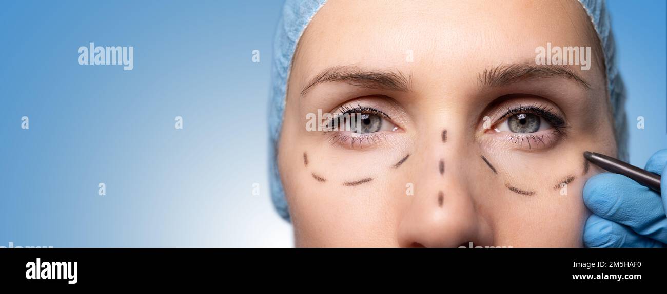 surgeon marking woman's face for cosmetic plastic surgery. facelift procedure. banner with copy space Stock Photo