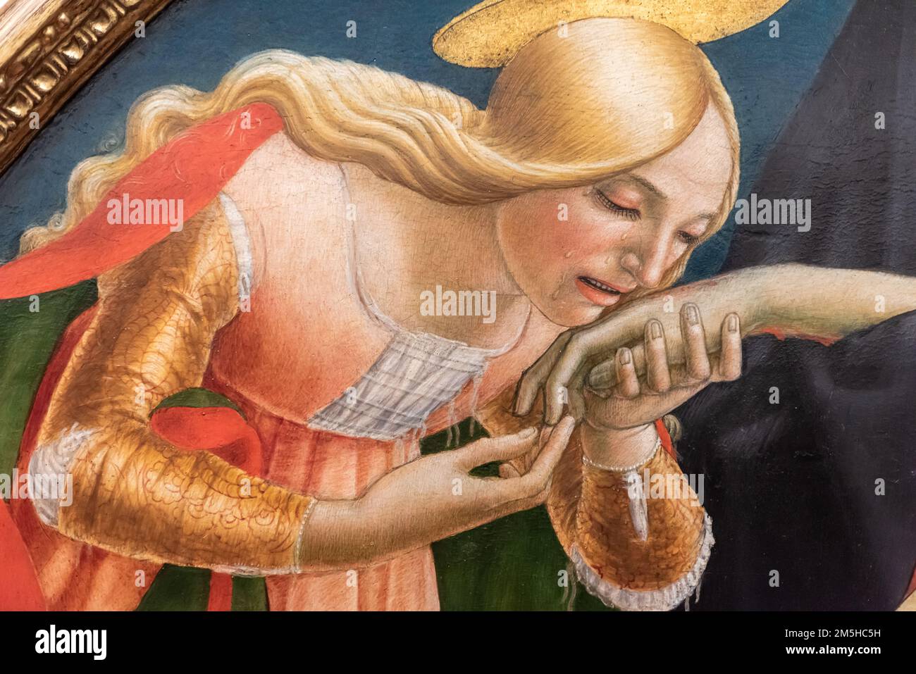 Close-up on medieval religious painting showing a blond female saint kissing dead Jesus´ hand Stock Photo