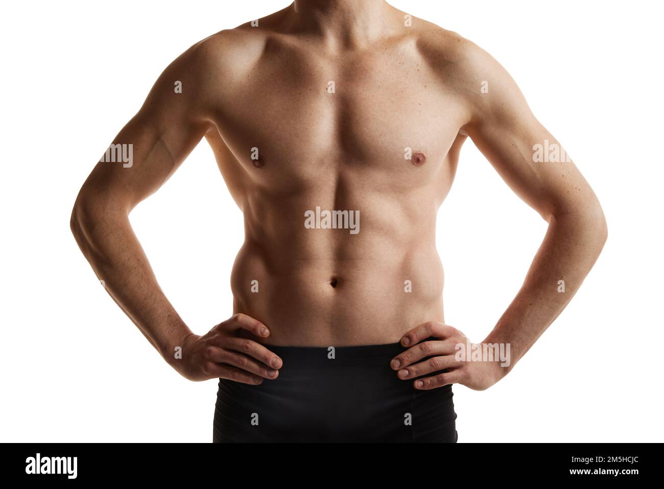 Cropped image of muscular male body, hands, belly. Man posing shirtless in black underwear over white studio background. Men's health and beauty Stock Photo