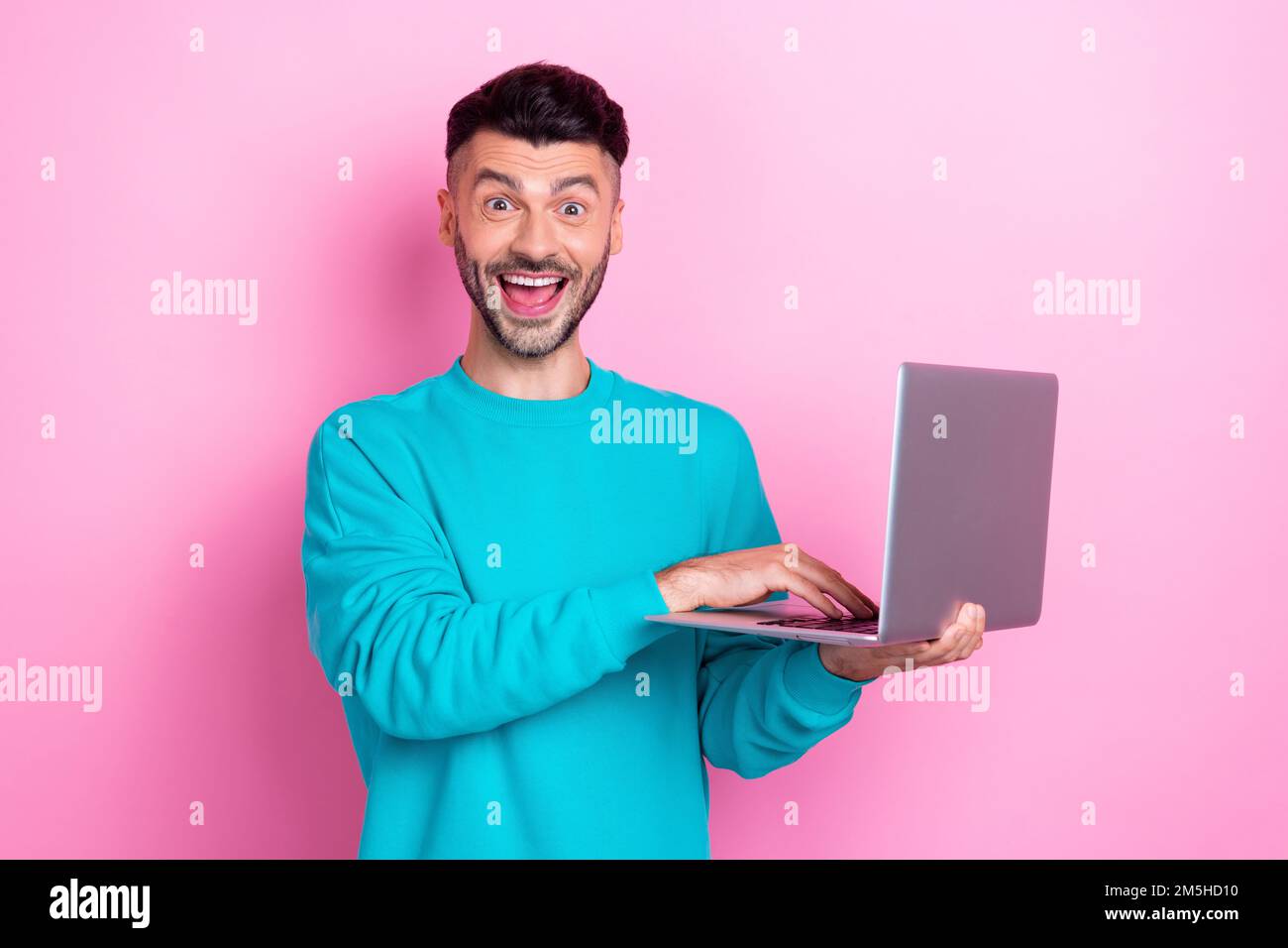 Photo of handsome funny face guy hold his laptop shock eshopping proposition cheap clothes from amazon isolated on pink color background Stock Photo Alamy