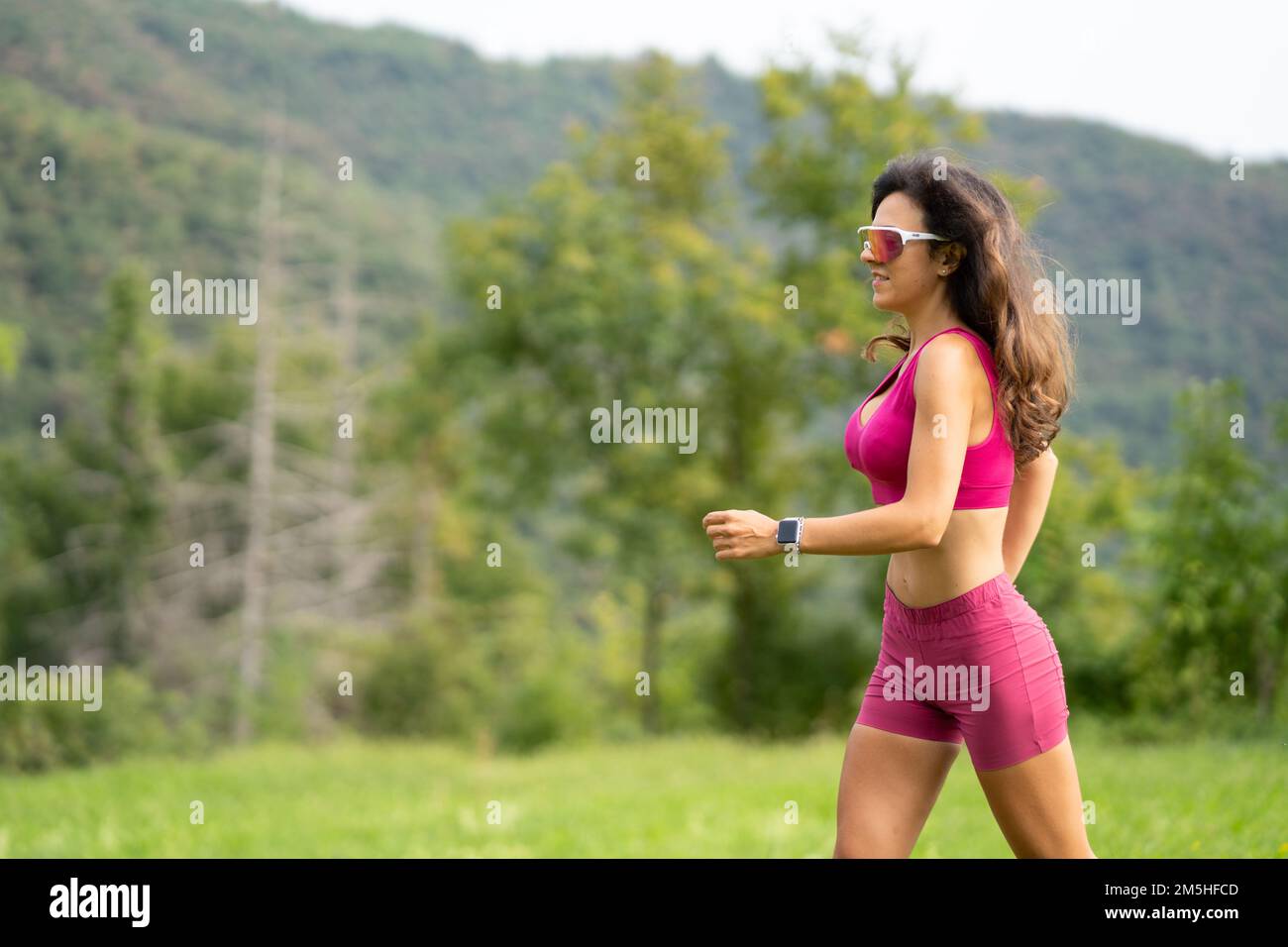 Trail running smiling girl runs uphill and on meadow Stock Photo Alamy