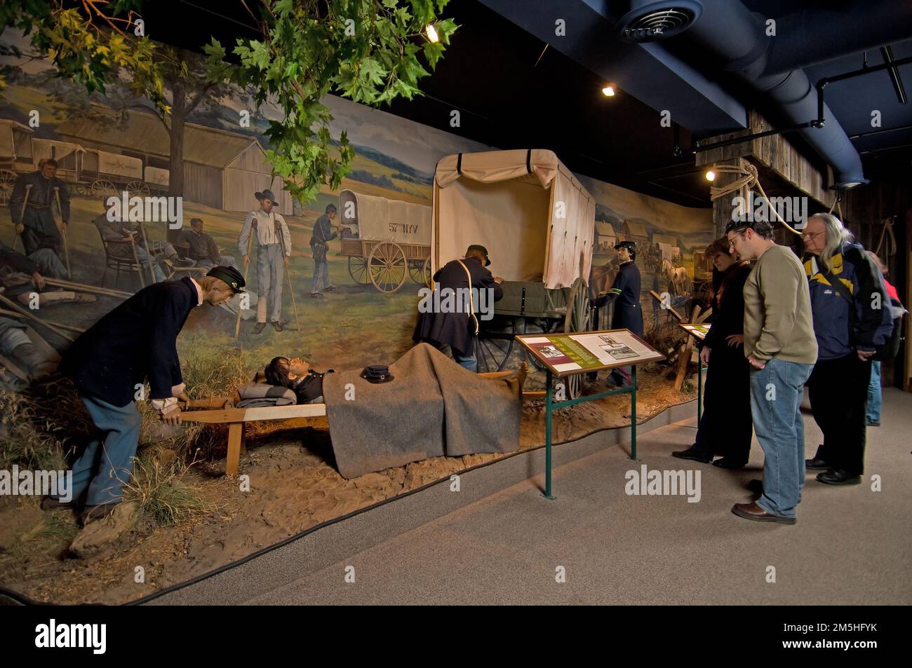 Historic National Road - National Museum of Civil War Medicine. Museum visitors read a plaque before a life-size display of Civil War soldiers treating their injured. Frederick, Maryland Stock Photo