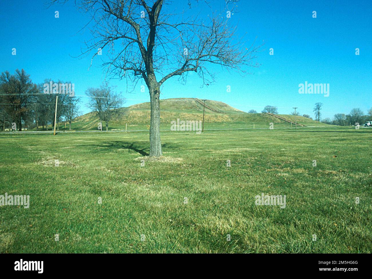Historic National Road - Cahokia Mounds State Historic Site. In the distance, the grass covered Monks Mound rises up from the flat surrounding area at Cahokia Mounds State Historic Site. Cahokia Mounds Historial Site, Illinois Stock Photo
