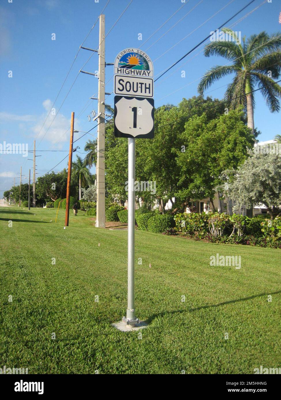 Florida Keys Scenic Highway - This Way to the Florida Keys Scenic Highway. The Florida Scenic Highway Program provides unique wayfinding signs to ensure travelers never get lost. These half-moon-shaped signs proudly display the Florida sunshine rising over another scenic highway. This sign along with the highway route number (US 1) that it is joined to clearly shows the way for the Florida Keys Scenic Highway. Location: Florida (24.572° N 81.747° W) Stock Photo