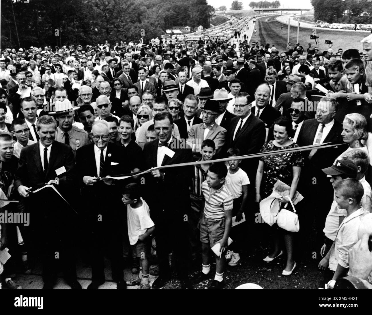 Photograph Taken in Maryland of the Ceremony Opening the Final Link of the Capital Beltway Around Washington, DC with Federal Highway Administrator Whitton and Maryland Governor Tawes Cutting the Ribbon, and John B. Funk, Chairman of the Maryland State Highway Commission Assisting. undefined. 1964-08-17T00:00:00. National Archives at College Park - Archives II (College Park, MD). Photographic Print. Department of Transportation. Federal Highway Administration. Office of Information and Management Services. Management Services Division. 1994- ?. General Photograph Files Stock Photo