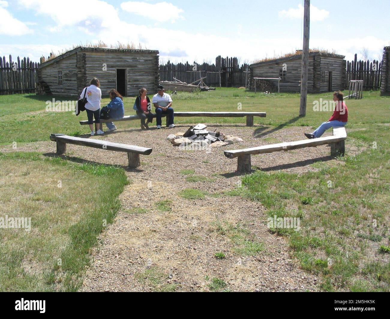 Native American Scenic Byway - Fort Manuel Lisa. Byway visitors rest on these benches in the center of restored Fort Manuel Lisa. The outbuildings and living quarters were reconstructed to match historical descriptions. Location: Near Kenel, South Dakota (45.858° N 100.460° W) Stock Photo