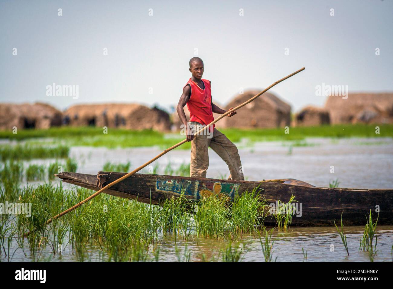 Man in a wooden boat (Pirogue) near  Mopti, Mali, West Africa. Stock Photo