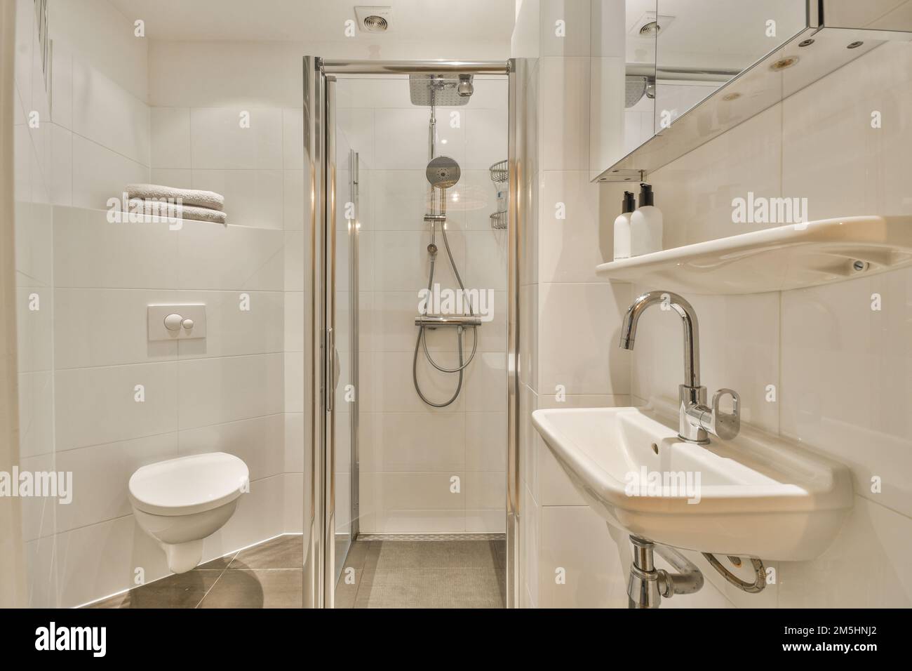 a bathroom with a sink, toilet and shower stall in the same room on the
