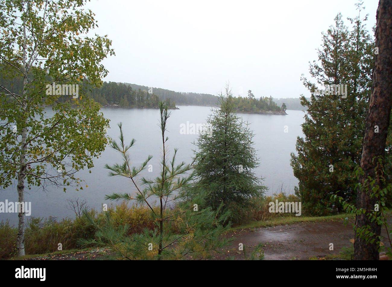 Gunflint Trail Scenic Byway - Seagull Lake. Trees frame a foggy morning view of a small island on Seagull Lake. Seagull Lake, Minnesota (48.140° N 90.874° W) Stock Photo
