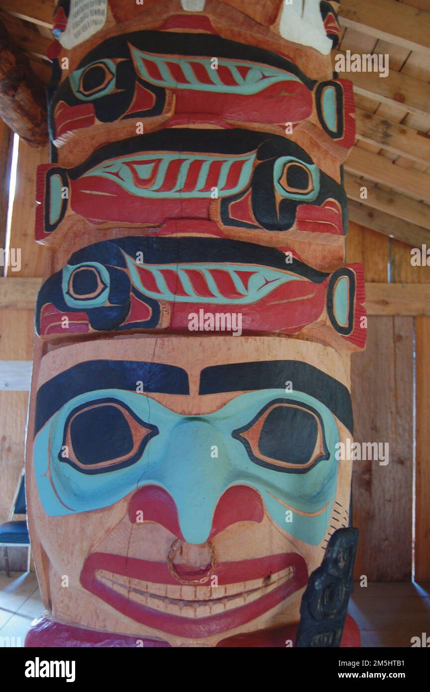 Haines Highway - Valley of the Eagles - Totem in the Klukwan Village Long House. A totem within the legendary walls of the Tlingit's Long House smiles at visitors, encouraging them on their journey. Haines, Alaska Stock Photo