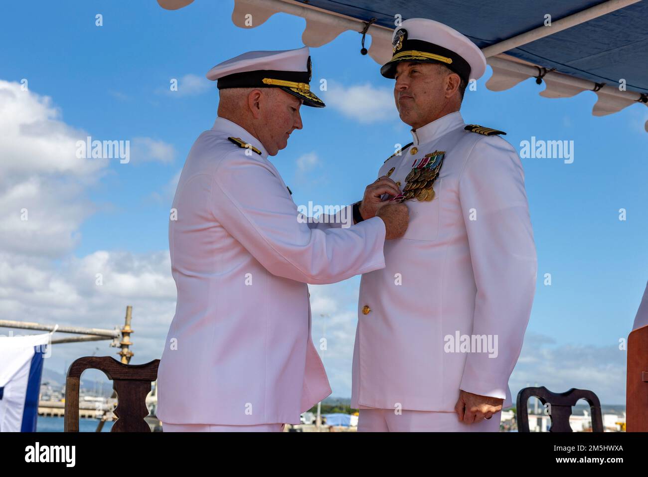 220318-N-OT701-1050 JOINT BASE PEARL HARBOR-HICKAM (Mar. 18, 2021) Rear Adm. Timothy Kott, Commander, Naval Surface Group Middle Pacific, pins a Legion of Merit award on Capt. Ken Athans during a change of command ceremony. Athans was relieved by Capt. Don Rauch as Commander, Destroyer Squadron 31 during the ceremony. Stock Photo