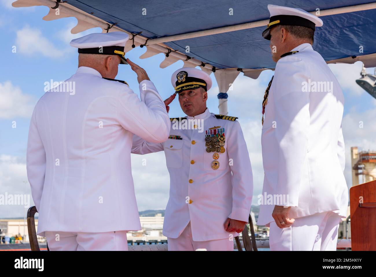 220318-N-OT701-1095 JOINT BASE PEARL HARBOR-HICKAM (Mar. 18, 2021) Capt. Don Rauch salutes Rear Adm. Timothy Kott, Commander, Naval Surface Group Middle Pacific, as he assumes command during a change of command ceremony. Capt. Ken Athans was relieved by Rauch as Commander, Destroyer Squadron 31 during the ceremony. Stock Photo