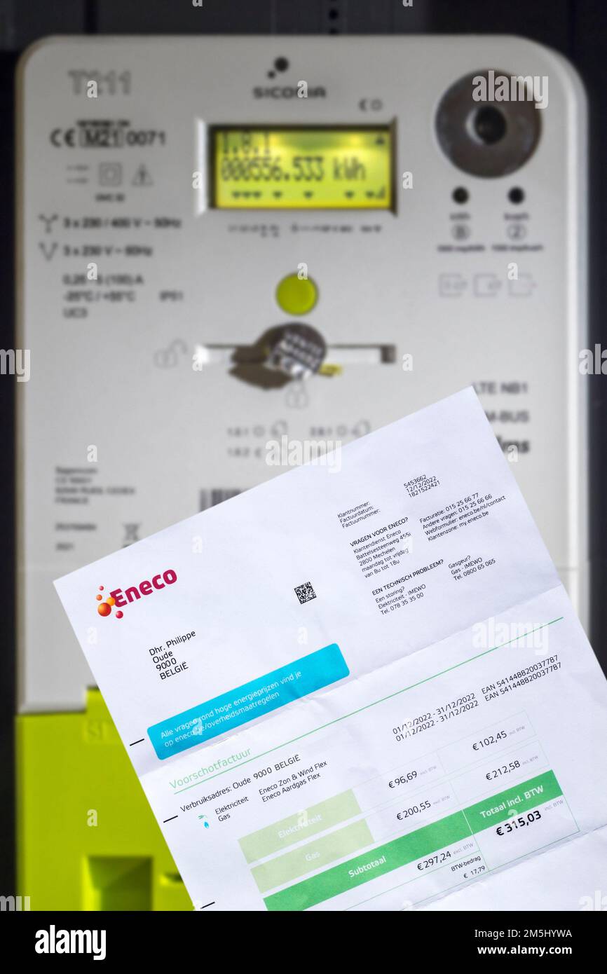 Invoice from Eneco, Belgian producer and supplier of natural gas and electricity in front of Fluvius smart meter in house in Belgium Stock Photo