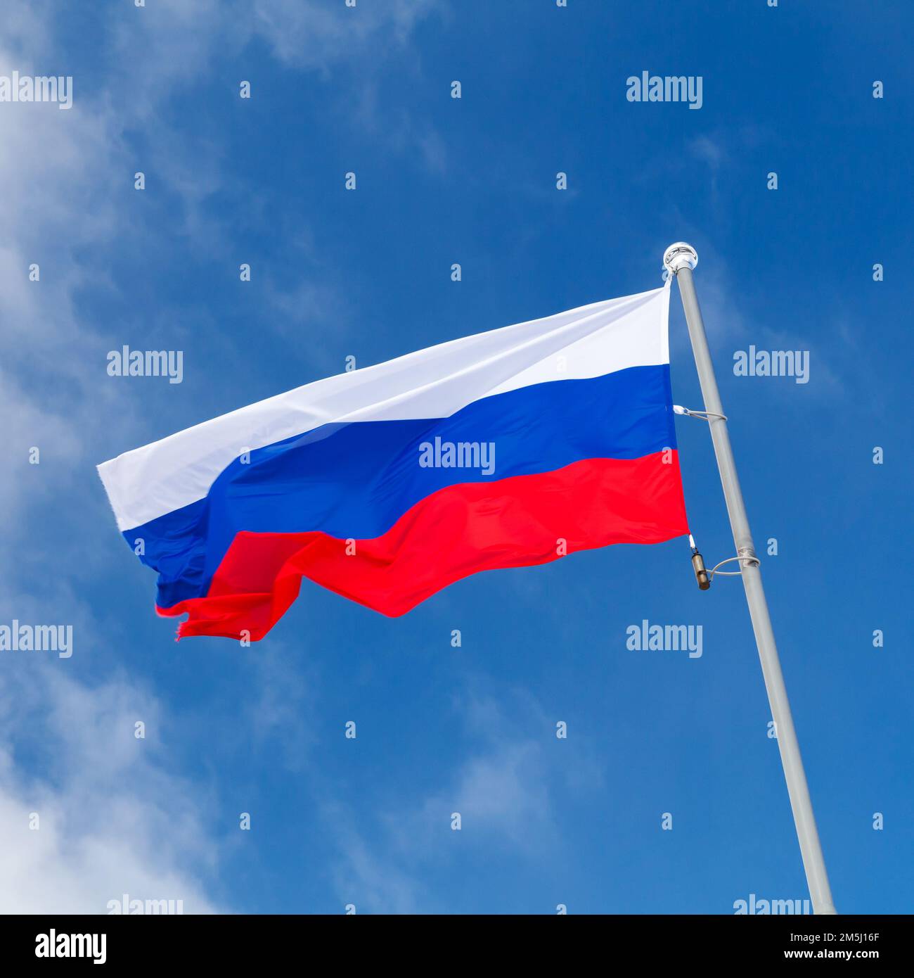 The national flag of Russia, also known as the State Flag of the Russian Federation is under blue sky on a sunny day, square photo Stock Photo