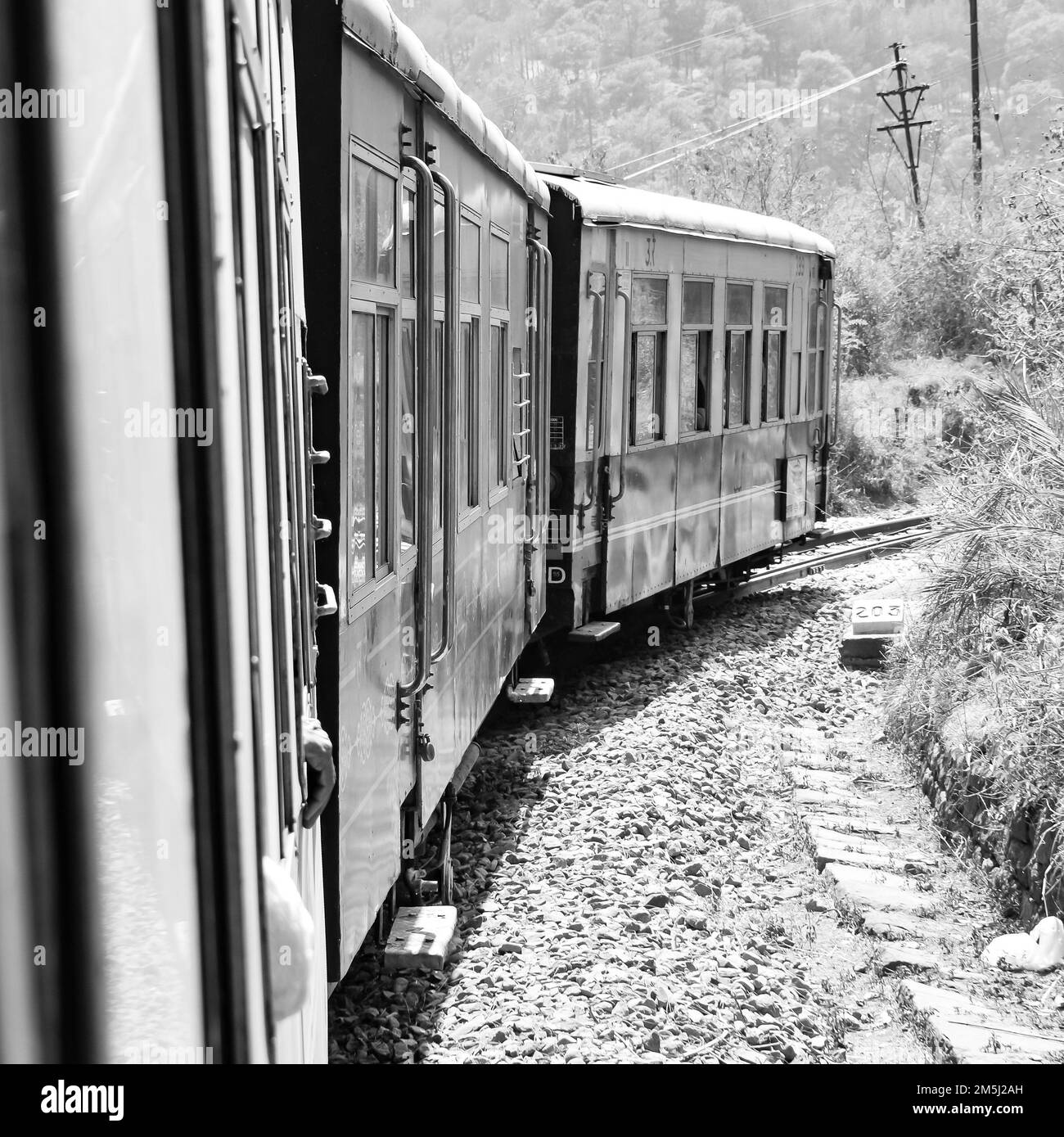 Toy Train moving on mountain slope, beautiful view, one side mountain, one side valley moving on railway to the hill, among green natural forest.Toy t Stock Photo