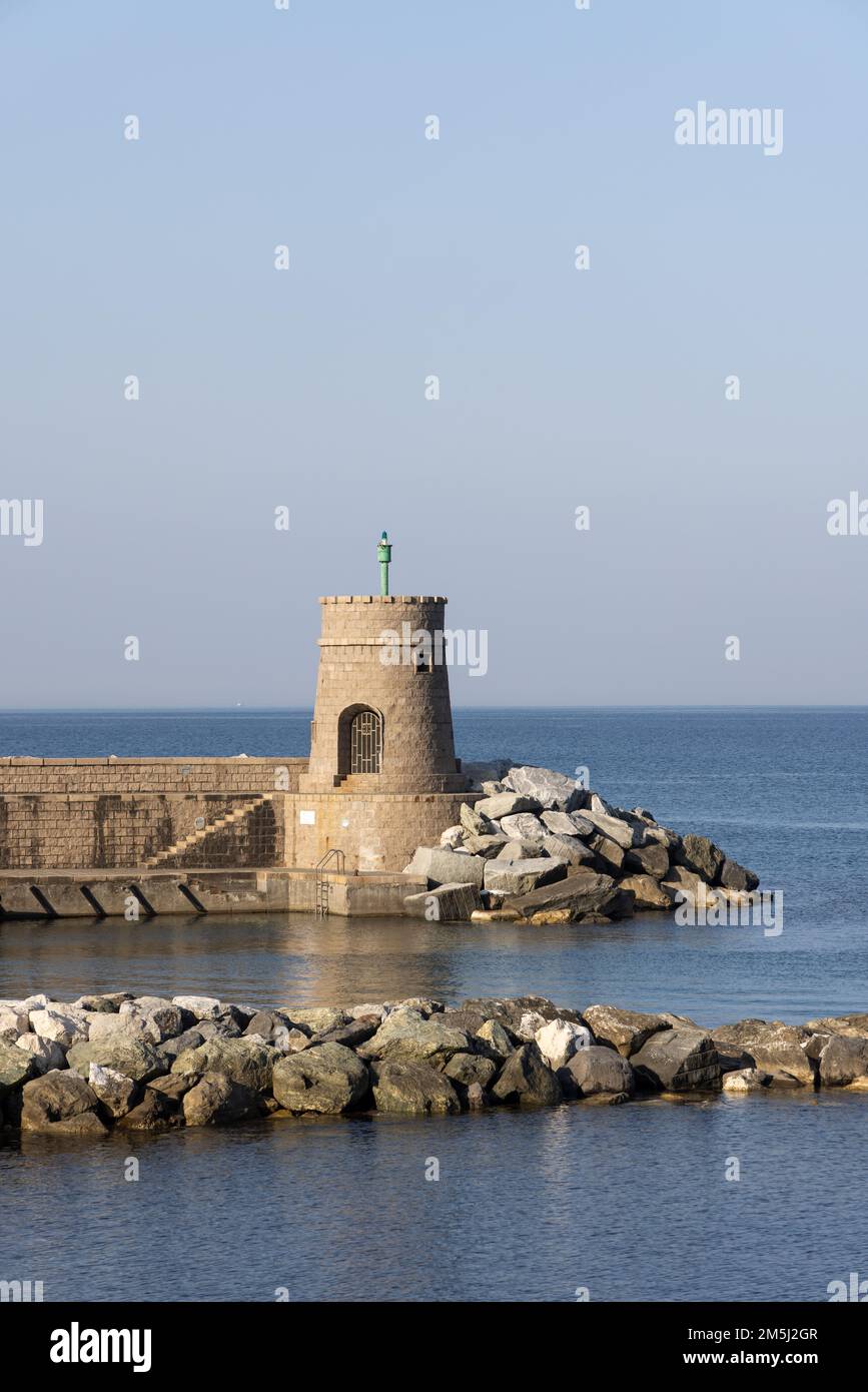Old small lighthouse and stone wave breakers of Recco on a sunny summer day. Recco is a comune in the Metropolitan City of Genoa, region of Liguria, I Stock Photo