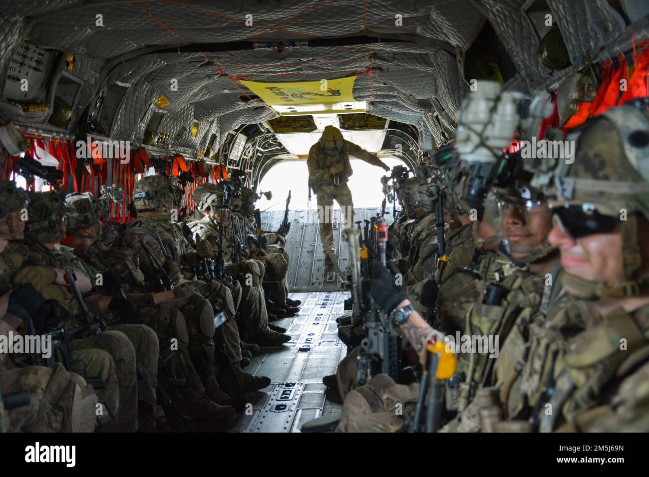 Black Lion Soldiers assigned to the 1st Battalion, 28th Infantry Regiment, 3rd Infantry Division sit on a CH-47 Chinook helicopter to conduct an air assault mission over Fort Stewart, Georgia, March 18, 2022. The air assault operation placed the 1st Bn., 28th IR into their Combined Arms Live Fire Exercise event to be conducted at Fort Stewart. A CALFX allows a maneuver company to incorporate indirect fires, aerial and sustainment assets to simulate realistic combat training. Stock Photo