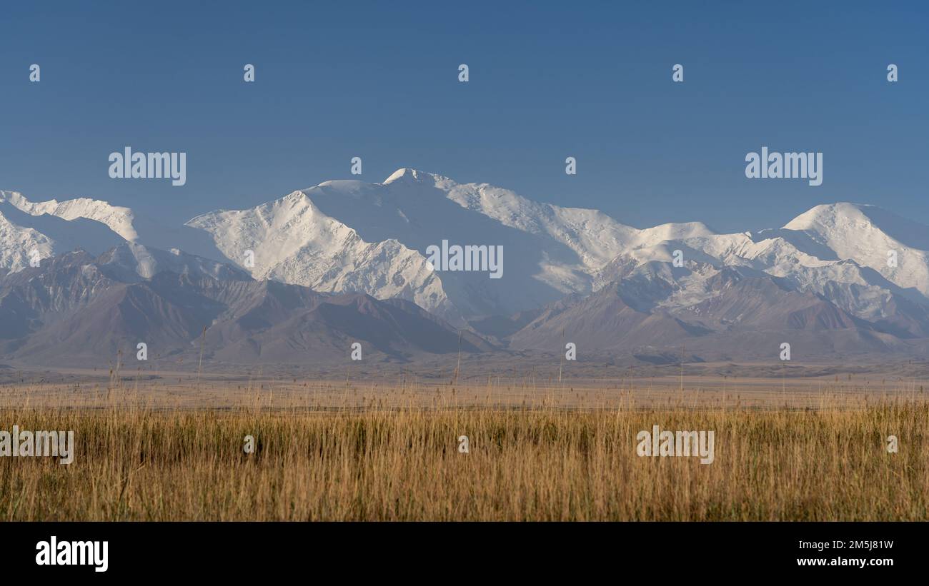 Morning landscape view of scenic snow-capped Trans-Alay mountain range with Lenin Peak aka Ibn Sina Peak, south Kyrgyzstan Stock Photo