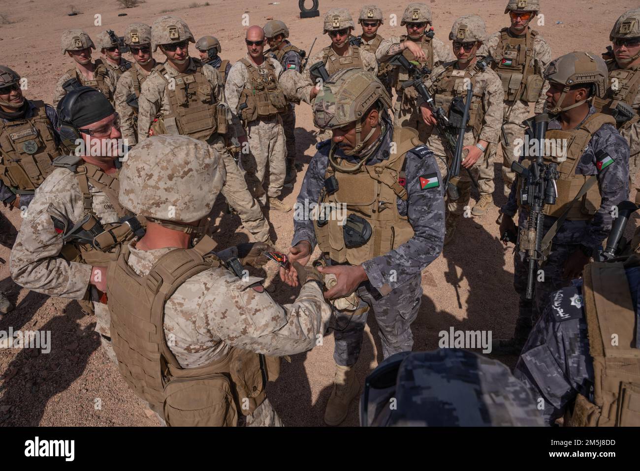 CAMP TITIN, Jordan (March 18, 2022) - A U.S. Marine assigned to Fox Company, 2nd Battalion, 24th Marines shakes hands and exchanges a patch with a Jordanian Marine from the 77th Royal Jordanian Marine Battalion after the final exercise (FINEX) of Intrepid Maven (IM) 22-1 aboard Camp Titin, Jordan, March 18. IM is a bilateral engagement series between U.S. Marine Corps Forces, Central Command and the Jordanian Armed Forces (JAF) that provides an opportunity to exchange military tactics and expertise. IM 22-1 is the first of multiple engagements scheduled between the U.S. Marine Corps and the JA Stock Photo
