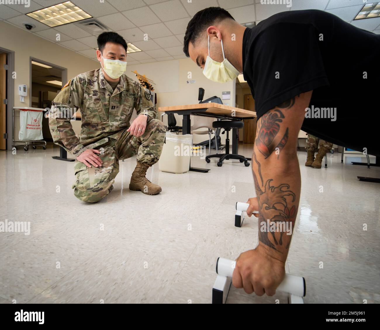 Capt. Brian Yu, occupational therapist, instructs a patient on