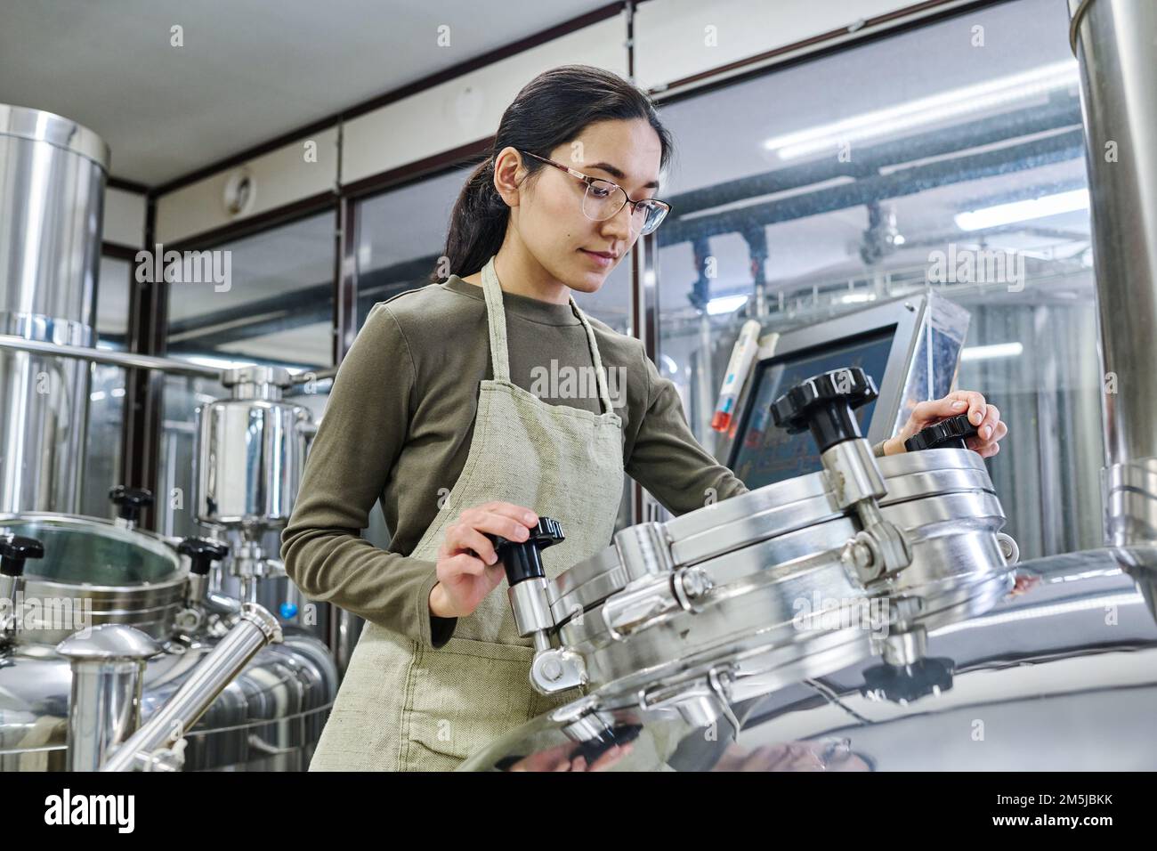 Female young engineer working on equipment to control the process of