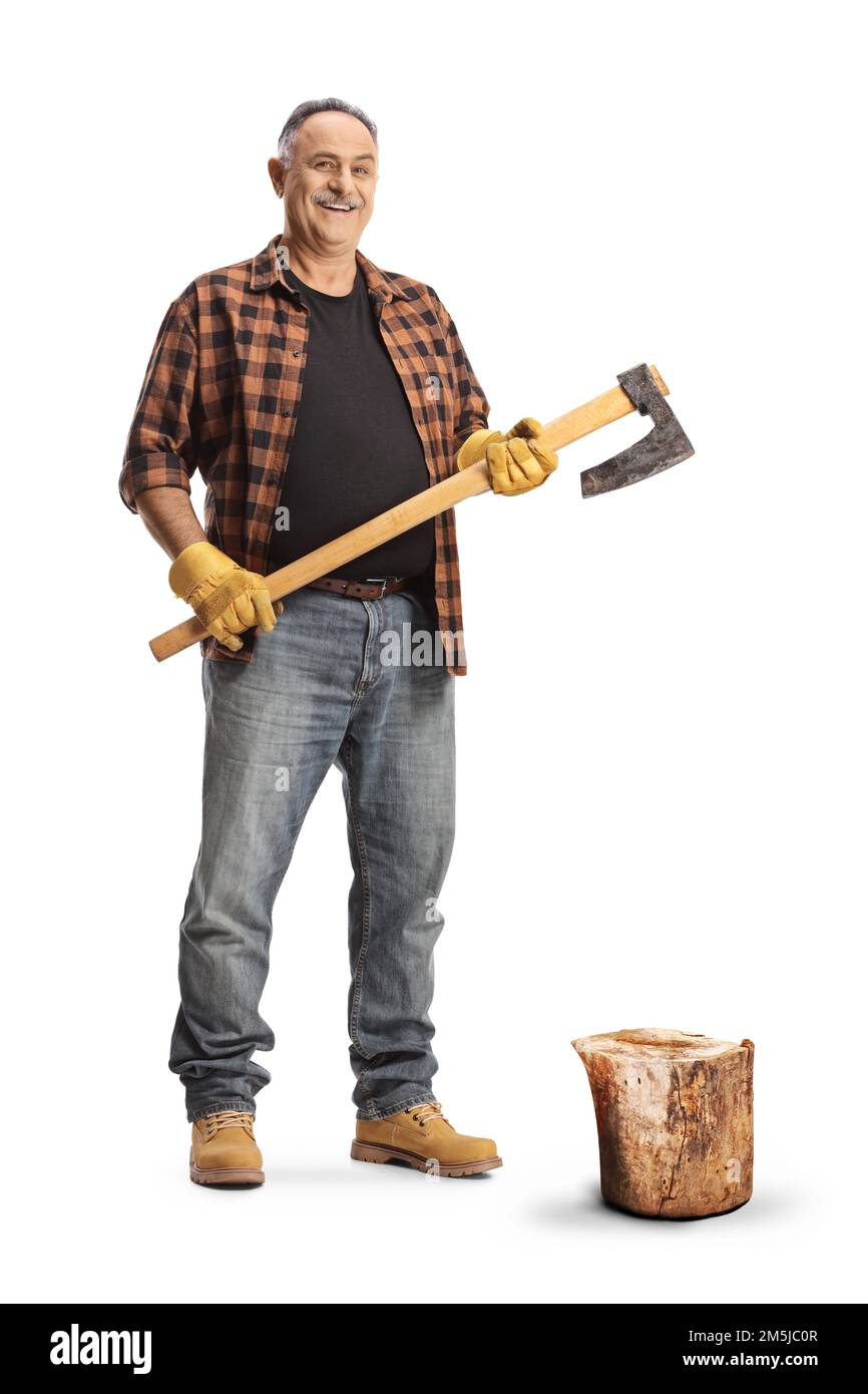 Full length portrait of a mature man next to a tree trunk holding an axe isolated on blue background Stock Photo