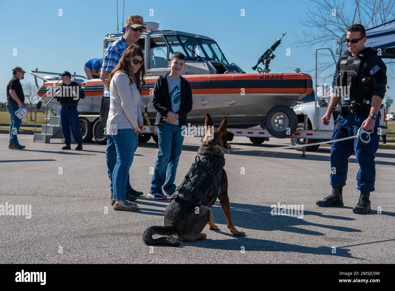 Members of the public talk with a Coast Guard K9 handler and his K9