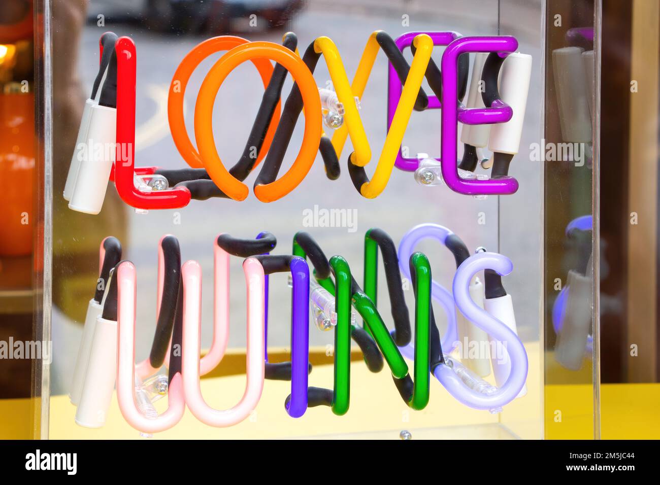 love wins message sign written in multi coloured neon in a shop window in great malvern worcestershire Stock Photo