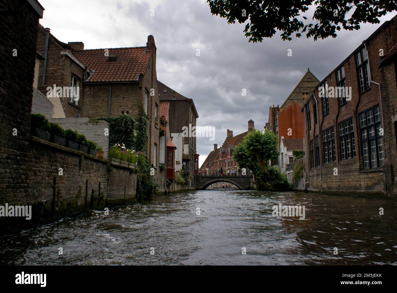 An old architectures with river between them and a bridge under cloudy ...