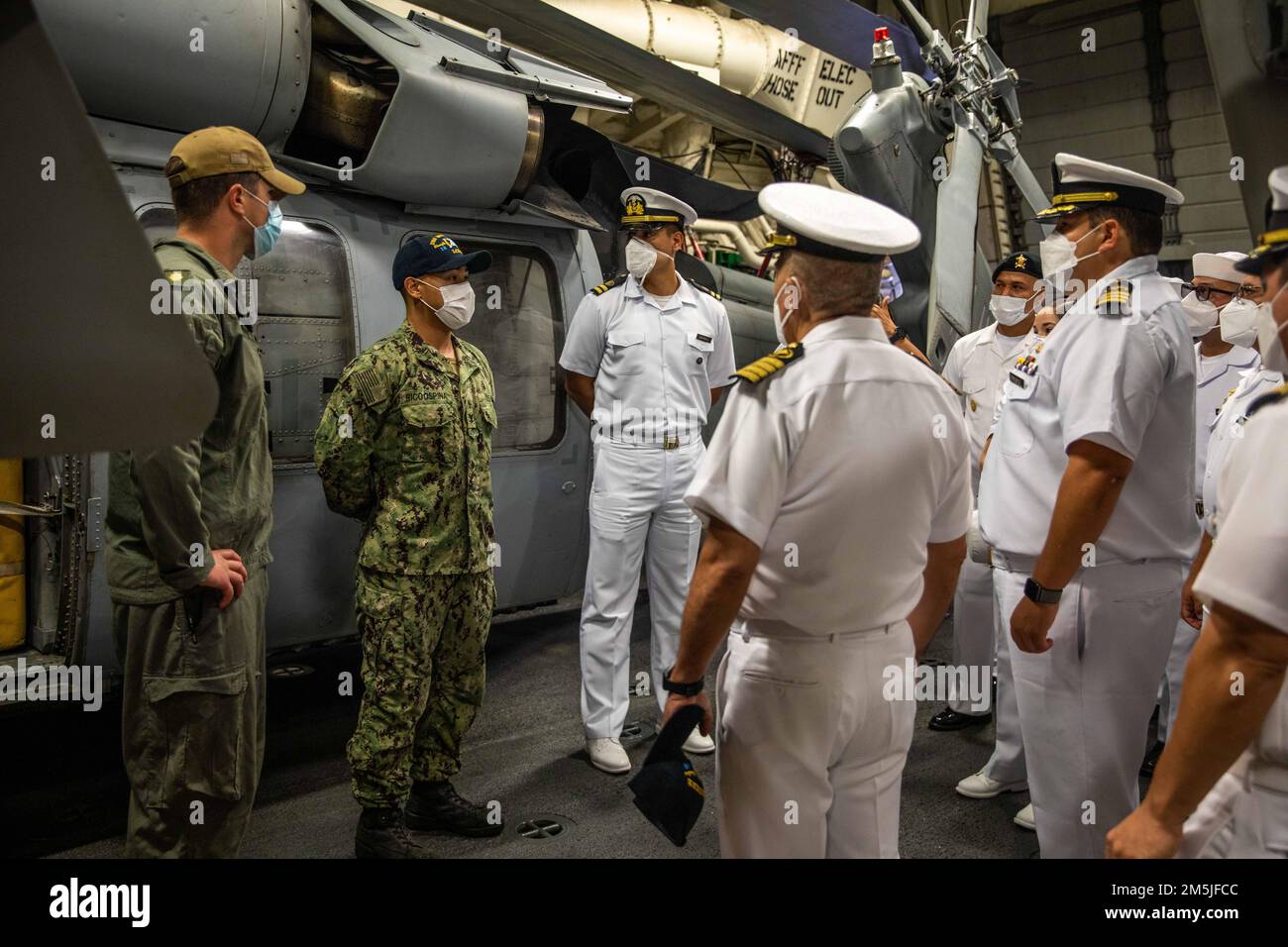 220319-N-HD110-1044  MANTA, Ecuador - (March 19, 2022) -- Aviation Machinist’s Mate 3rd Class Felix Ricoospina, middle, assigned to the “Sea Knights” of Helicopter Sea Combat (HSC) Squadron 22, Detachment 5, discusses the capabilities of the MH-60S Sea Hawk helicopter to Ecuadorian navy sailors during their visit to the Freedom-variant littoral combat ship USS Milwaukee (LCS 5), March 19, 2022. Milwaukee is deployed to the U.S. 4th Fleet area of operations to support Joint Interagency Task Force South’s mission, which includes counter-illicit drug trafficking missions in the Caribbean and East Stock Photo
