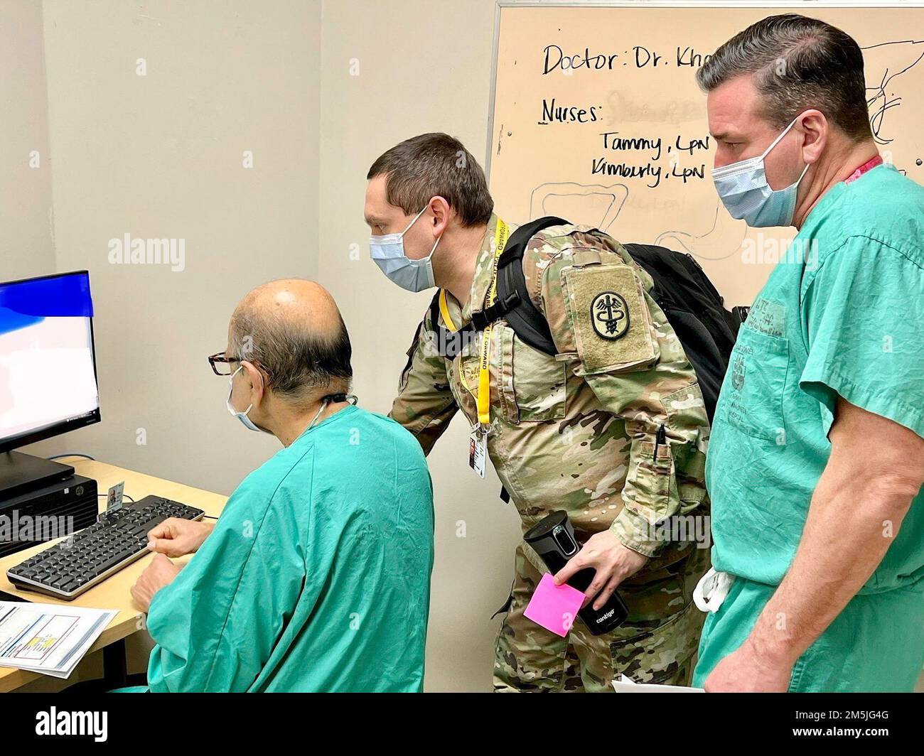 Maj. Steven Werner, “pay it forward” provider from, Weed Army Community Hospital, National Training Center and Fort Irwin, California assists Mohamed F. Kahn (left), general surgeon and Lt. Col. Jeffery White (right) orthopedic surgeon, from Bayne-Jones Army Community Hospital during MHS GENESIS “go live” at the Joint Readiness Training Center and Fort Polk, Louisiana on March 19. MHS GENESIS is the modernized electronic health record that integrates inpatient and outpatient medical and dental information across the continuum of care worldwide, from point of injury to the military treatment fa Stock Photo