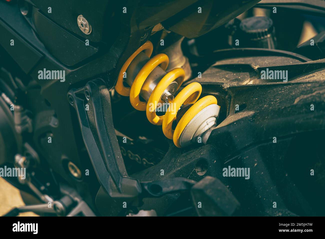 A detailed view of a motorcycle rear suspension under the sunlight