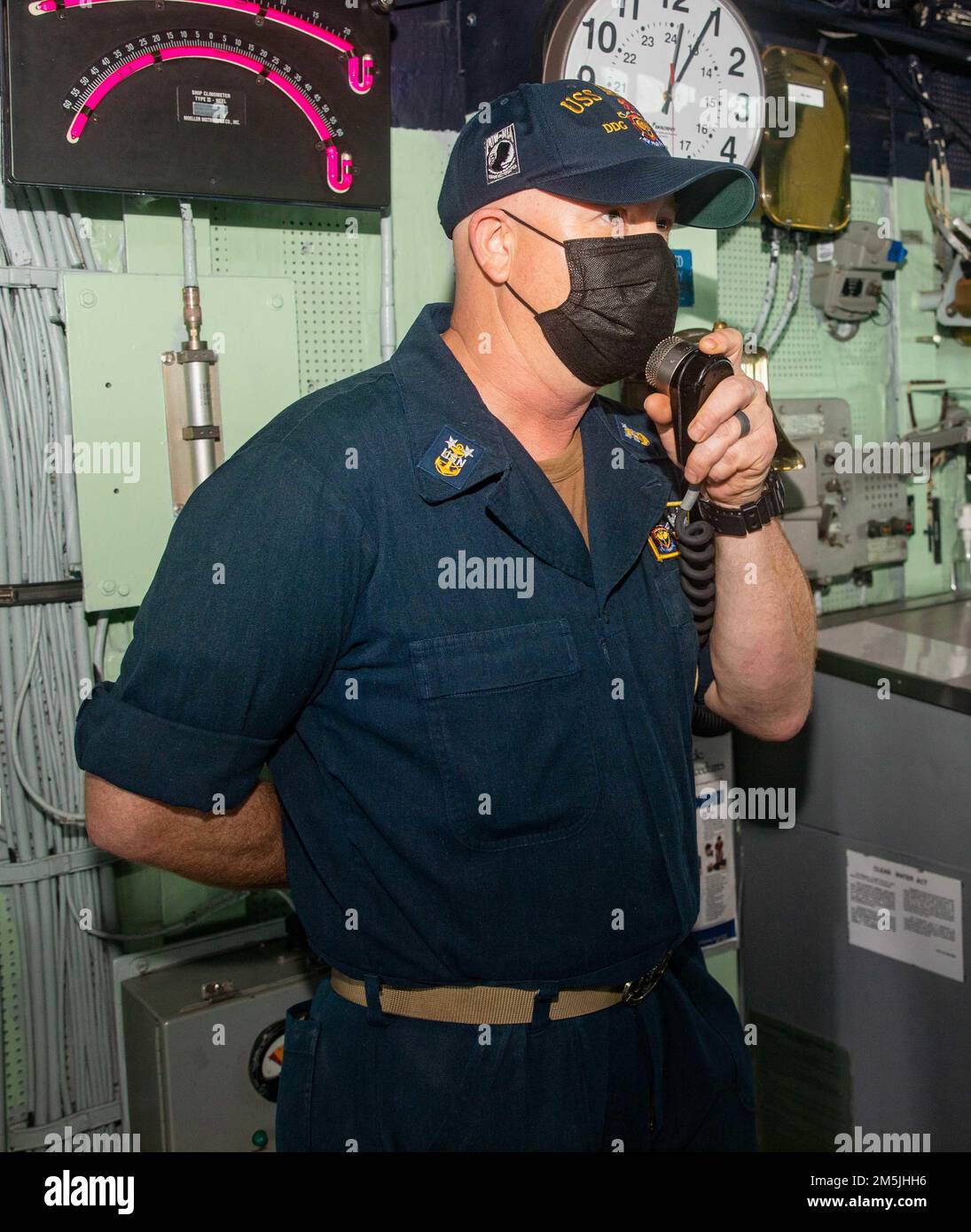 220319-N-KW492-1014 PHILIPPINE SEA (March 19, 2022) Command Master Chief Troy Bojorquiz, from Yucaipa, California makes an announcement to the crew on the ship’s intercom in the bridge of the Arleigh Burke-class guided-missile destroyer USS Milius (DDG 69). Milius is assigned to Destroyer Squadron (DESRON) 15, Navy’s largest forward-deployed DESRON and the U.S. 7th Fleet’s principal fighting force, and is underway supporting a free and open Indo-Pacific. Stock Photo
