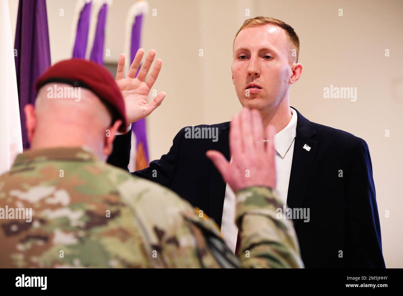Maj. Gen. Jeffrey Coggin, left, commanding general of the U.S. Army Civil Affairs and Psychological Operations Command, administers an oath to U.S. Army Reserve Capt. Ryan Hooper, right, a 7th grade teacher in Philadelphia, making him the first Soldier to be directly commissioned as a civil affairs military government specialist at Fort Hamilton, N.Y., March 19, 2022. The new civil affairs military government specialist position will enable civilian and military personnel with experience in various career fields to be commissioned as officers in the U.S. Army. Stock Photo