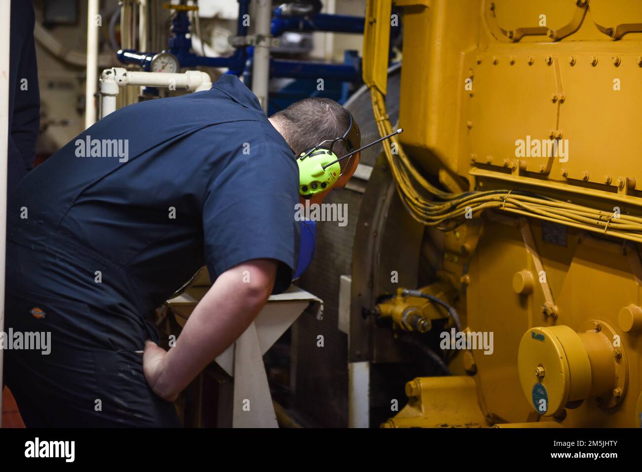 U.S. Coast Guard Petty Officer 3rd Class Frank Aurelio, an Electricians Mate aboard Coast Guard Cutter Spar, checks the engine while underway in the Atlantic Ocean, March 19, 2022. Spar and her crew are traveling to Duluth, Minn. after a year-long maintenance period in Baltimore. Stock Photo