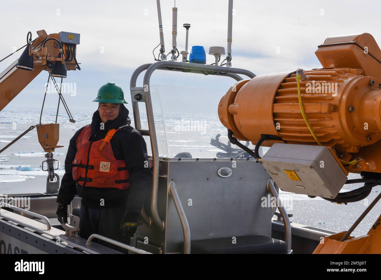 U.S. Coast Guard Petty Officer 3rd Class Adolfo Hernandez, a Machinery Technician aboard Coast Guard Cutter Spar, poses for a photo on the small boat after conducting checks while underway in the Atlantic Ocean, March 19, 2022. Spar and her crew are traveling to Duluth, Minn. after a year-long maintenance period in Baltimore. Stock Photo