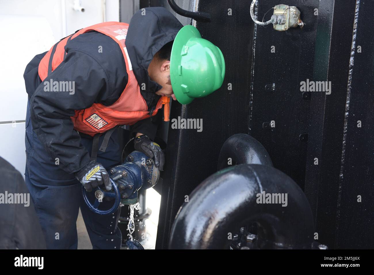 U.S. Coast Guard Petty Officer 3rd Class, Adolfo Hernandez, a Machinery Technician onboard Coast Guard Cutter Spar, winterizes the water hookup to prepare for the colder climate while in the Atlantic Ocean, March 19, 2020. Spar and her crew are traveling to Duluth, Minn. after a year-long maintenance period in Baltimore. Stock Photo