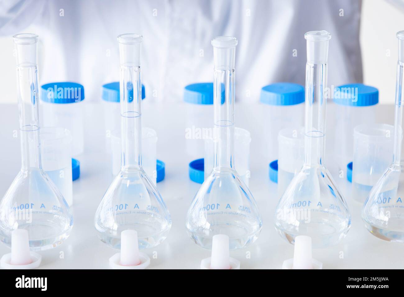 Close up laboratory glassware for analysis. Flasks and plastic bottles