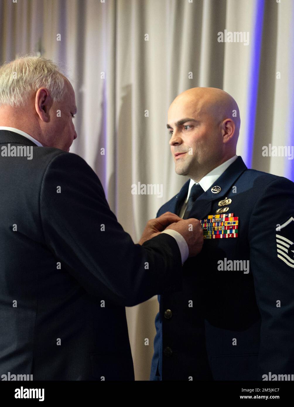 U.S. Air Force Master Sgt. Shane Trisco, 133rd Maintenance Group, right, received the Meritorious Service Medal from Minnesota Gov. Tim Walz in St. Paul, Minn., March 19, 2022. During a recent deployment, Trisco provided excellent administrative and personnel duties for the largest maintenance organization within the U.S. Air Forces Central Command by leading 11 members and 22 programs for over 1,000 Airmen, which generated more than 5,000 combat missions in support of Operations INHERENT RESOLVE and FREEDOM’S SENTINEL. Stock Photo