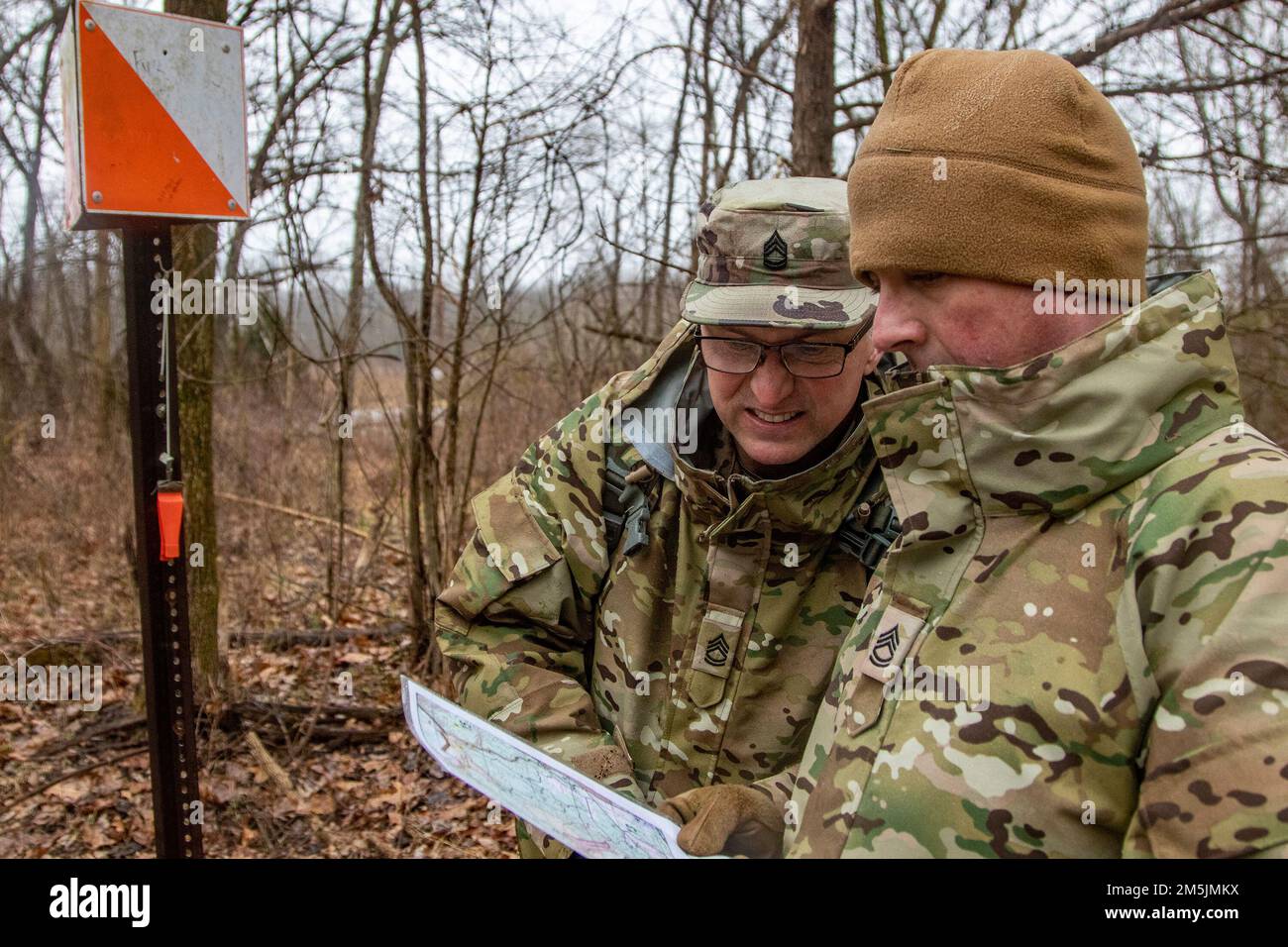 U.S. Army Sgt. 1st Class Rodney Brough, right, and Sgt. 1st Class Larry May, left, both instructors with Company B, 4th Battalion, 399th Regiment, look at their next point on the map after successfully locating one during land navigation training March 19, 2022, on Fort Knox. Ky. Soldiers from 4th Bn., 399th Regt., who serve as Cadet Summer Training instructors, conducted land navigation refresher training before traversing the course to find their specified points during March Battle Assembly. Stock Photo