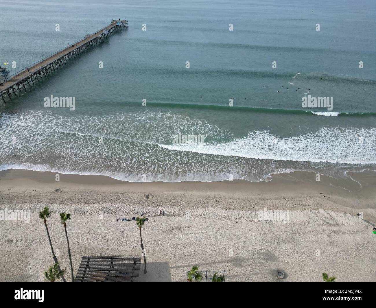 An aerial view over sandy beach and San Clemente Pier on sthe horizon