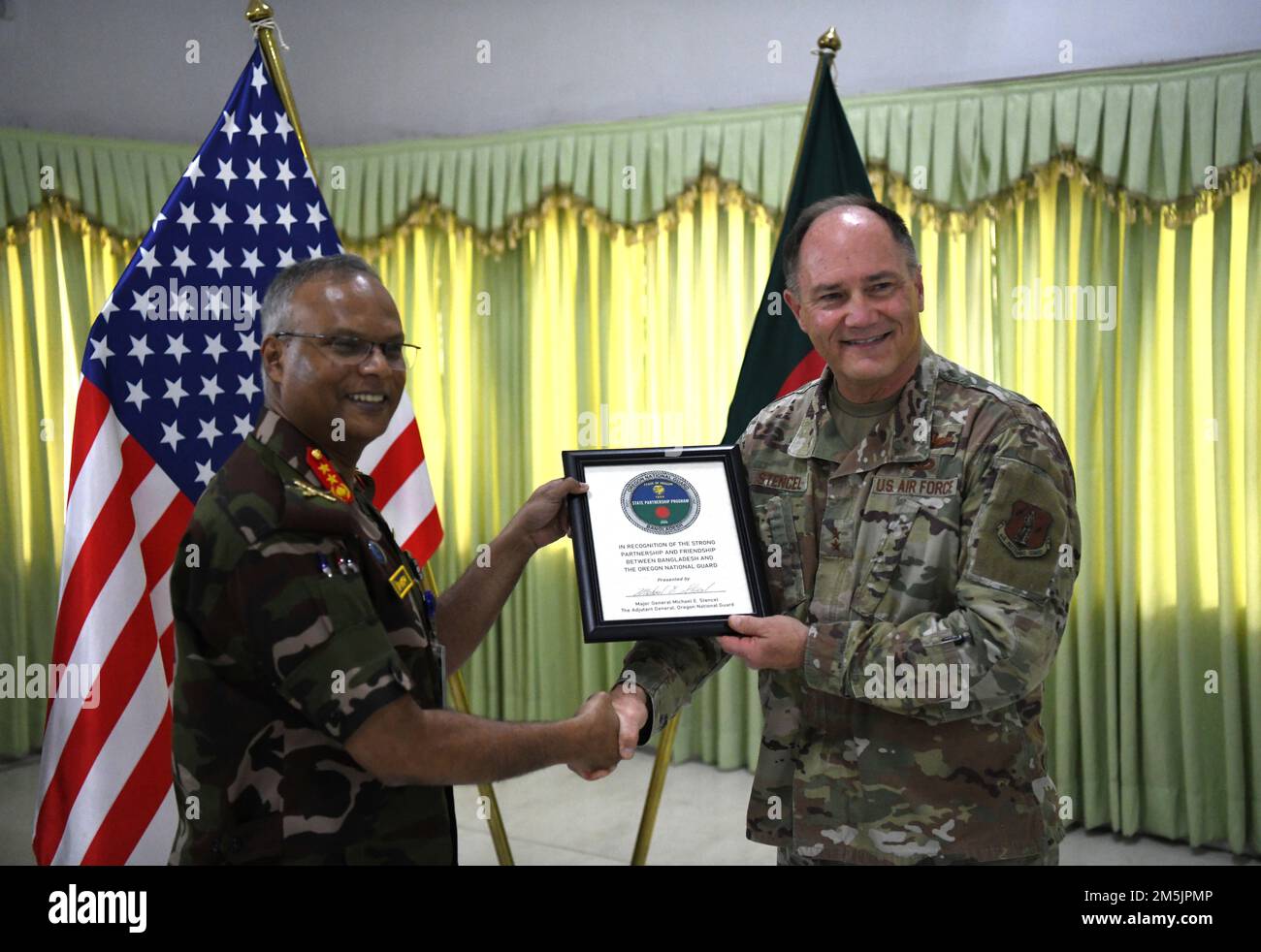 Maj. Gen. Michael Stencel, Adjutant General, Oregon (right) presents a plaque to Maj. Gen. A S M Ridwanur Rahman, Commandant of the Bangladesh Institute of Peace Support Operation Training (BIPSOT) center in Dhaka, Bangladesh March 20, 2022. Delegates from the Oregon National Guard are attending Exercise Tiger Lightning 2022, which is a bilateral exercise sponsored by the U.S. Indo-Pacific Command and hosted by the Bangladesh Armed Forces, strengthening Bangladesh defense readiness, building operational interoperability, and reinforcing partnership between the Bangladesh Armed Forces and the O Stock Photo