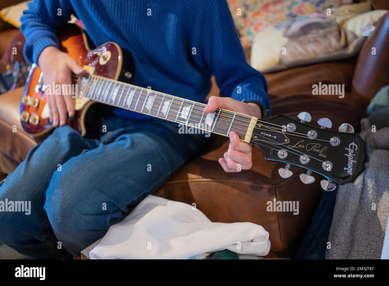 A male teenager playing an electric guitar he got for Christmas - a Gibson Les Paul Model Epiphone - a vintage model. England Stock Photo