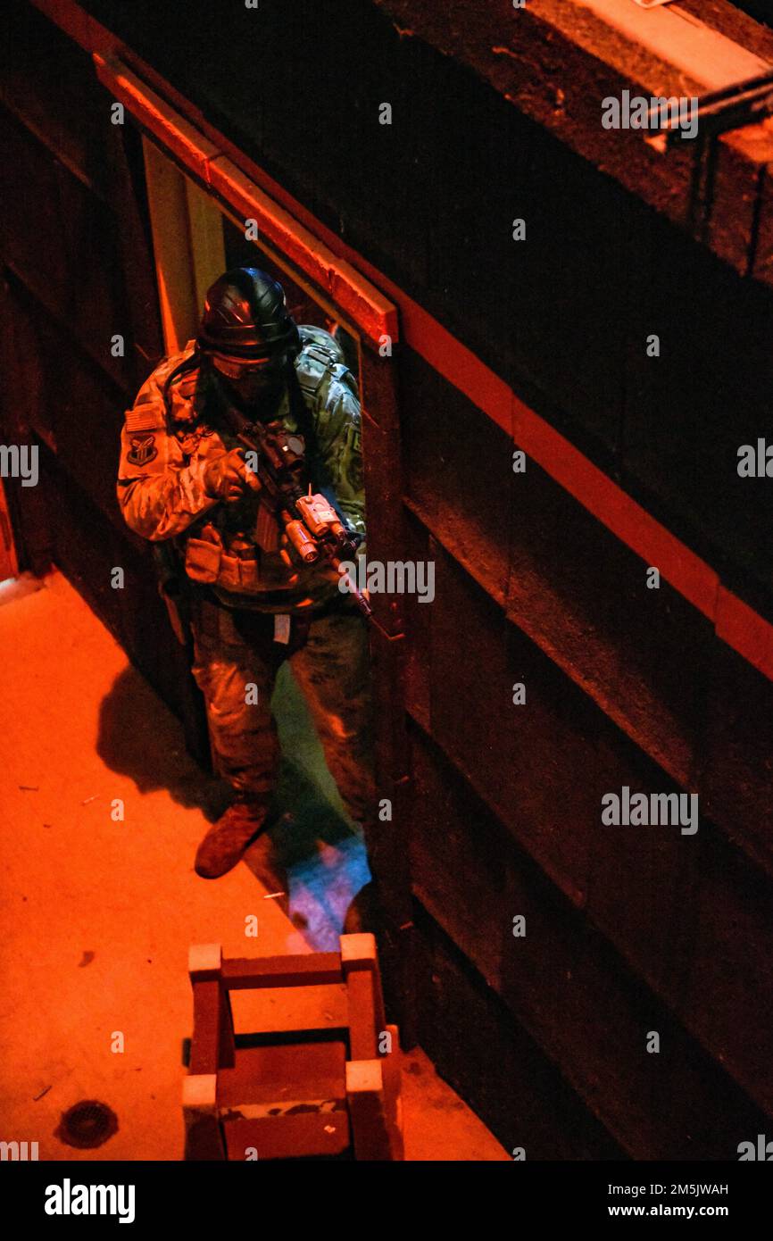 An Air Force Reserve Command Defender assigned to the 446th Security Forces Squadron, Joint Base Lewis-McChord, Washington, works through a live-fire training scenario, March 20, 2022, at the shoot-house at Camp James A. Garfield Joint Military Training Center, Ohio. The scenario incorporated dye-marker round engagements with opposing force members as the Defenders attempted to clear the building of hostiles. The shoot-house training is part of the two-week Integrated Defense Leadership Course at CJAG and Youngstown Air Reserve Station, Ohio. Cadre members increased the challenge level of the Stock Photo