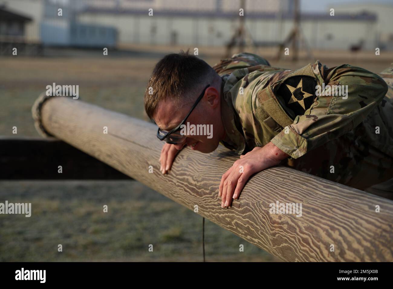 Sgt. Nathaniel Declue a Combat Medic Specialist assigned to 3-2 General Support Aviation Battalion, 2nd Combat Aviation Brigade, 2nd Infantry Division, attempts the log roller event during the Best Warrior Competition Obstacle Course, 21 Mar. 2022, Camp Humphreys, Republic of Korea. The BWC is held to recognize the best Soldiers of the 2CAB through various tests including a ruck march, obstacle course and a Soldier of the quarter board. Stock Photo