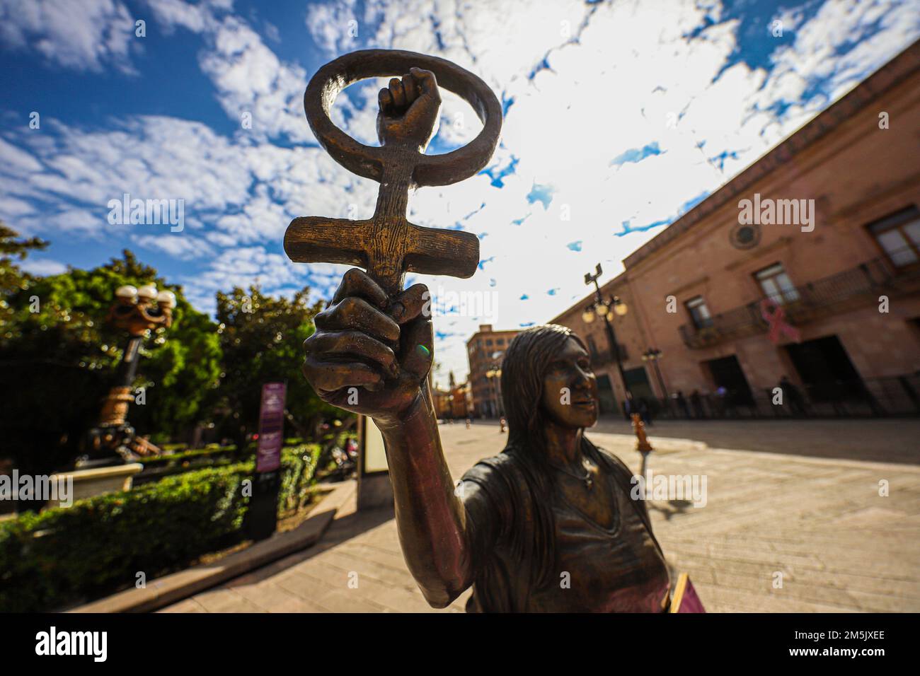 Statue of a woman and the symbol of the feminist movement, lgbt in the square in front of the government palace of San Luis Potosí Mexico. femenicide. San Luis Potosí, It was an important gold and silver mining center on the Camino Real de Tierra Adentro, a commercial route from the mid-16th century to the 19th century colonial buildings, such as the imposing Baroque-era Temple of San Francisco, which dominates the leafy Garden of San Francisco. Nearby is the Templo del Carmen, dating from the 18th century.  (photo By Luis GutierrezNortePhoto)    Estatua de mujer y el simbolo del movimiento f Stock Photo