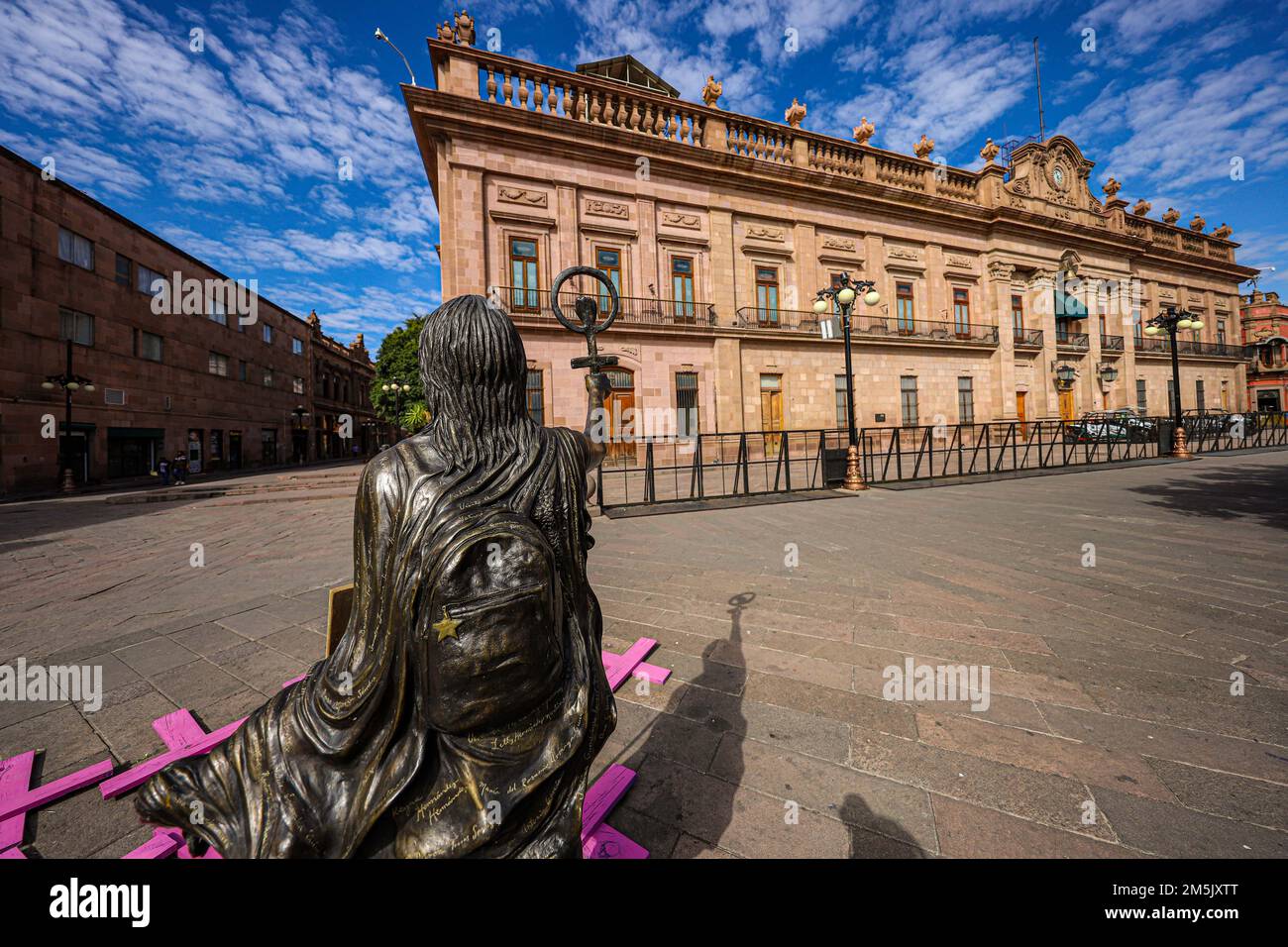 Statue of a woman and the symbol of the feminist movement, lgbt in the square in front of the government palace of San Luis Potosí Mexico. femenicide. San Luis Potosí, It was an important gold and silver mining center on the Camino Real de Tierra Adentro, a commercial route from the mid-16th century to the 19th century colonial buildings, such as the imposing Baroque-era Temple of San Francisco, which dominates the leafy Garden of San Francisco. Nearby is the Templo del Carmen, dating from the 18th century.  (photo By Luis GutierrezNortePhoto)    Estatua de mujer y el simbolo del movimiento f Stock Photo