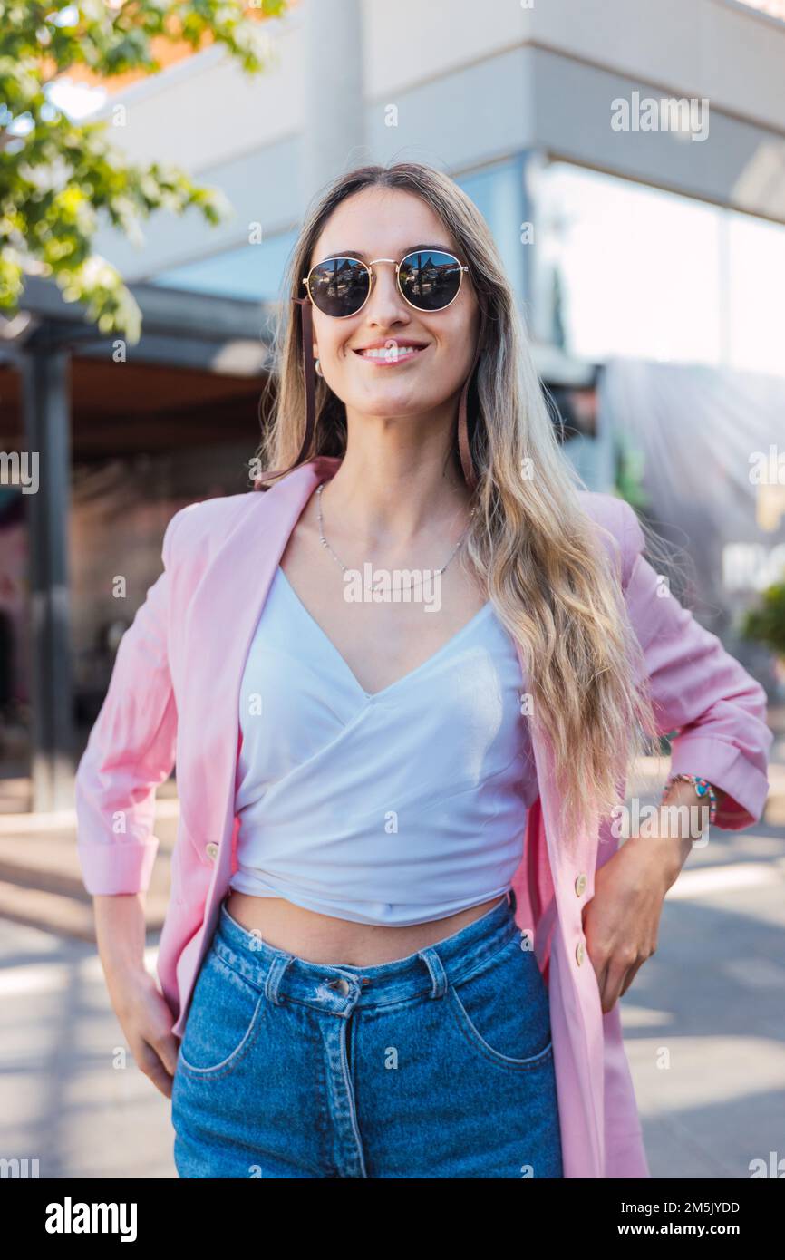 Confident and empowered young woman smiling and standing outside the mall. Feminine determination Stock Photo